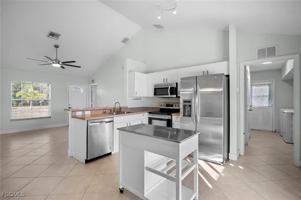 a kitchen with kitchen island a counter top space appliances and cabinets