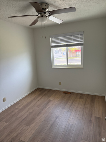 747 Hanover Drive Orem, UT 84058 - Photo 14 of 30 Spare room with a textured ceiling, a ceiling fan, and wood finished floors