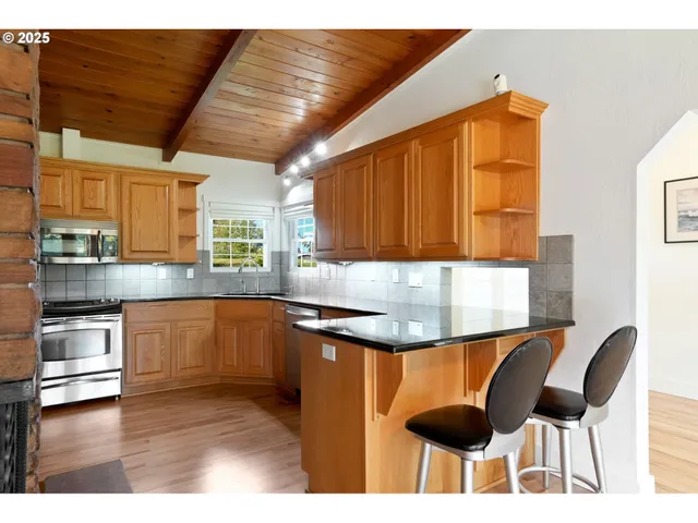 a kitchen with granite countertop a stove a sink and a microwave