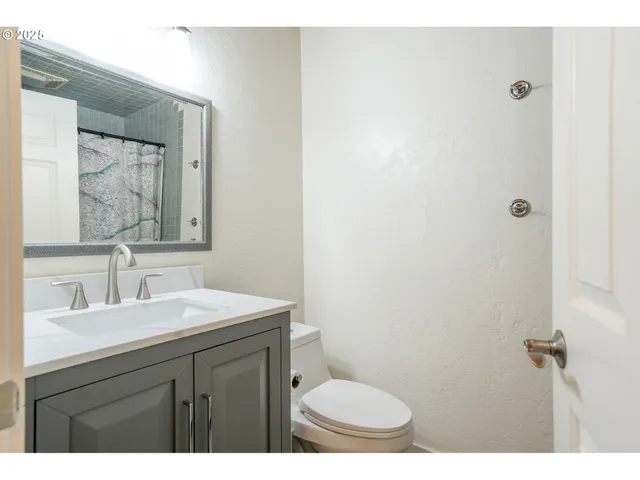 a bathroom with a sink a toilet and mirror