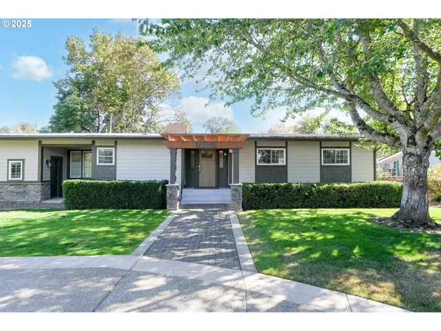 a front view of a house with a yard and potted plants