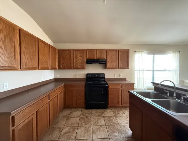 a kitchen with stainless steel appliances granite countertop a sink stove and cabinets