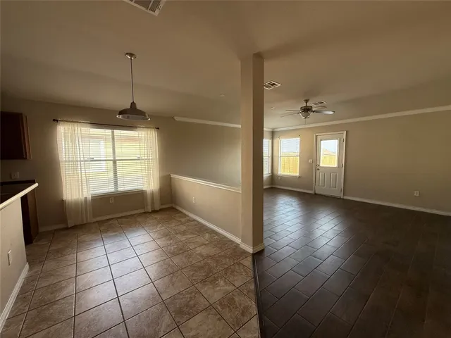 a view of an empty room with window and wooden floor