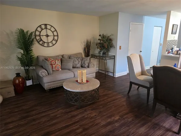 a living room with furniture and a wooden floor