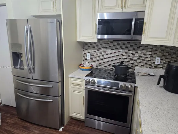 a kitchen with granite countertop a stove and a microwave