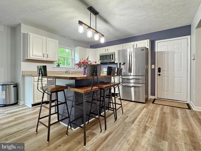 a kitchen with stainless steel appliances granite countertop a sink dishwasher a stove and a microwave oven with cabinets