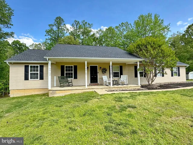 a view of a dining room and livingroom with furniture wooden floor a chandelier