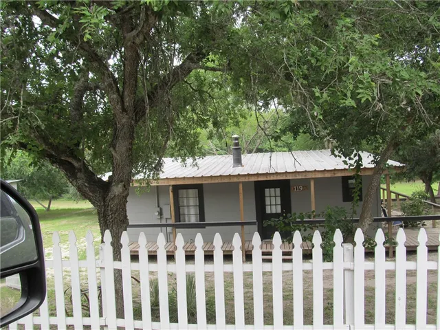 a front view of a house with a tree