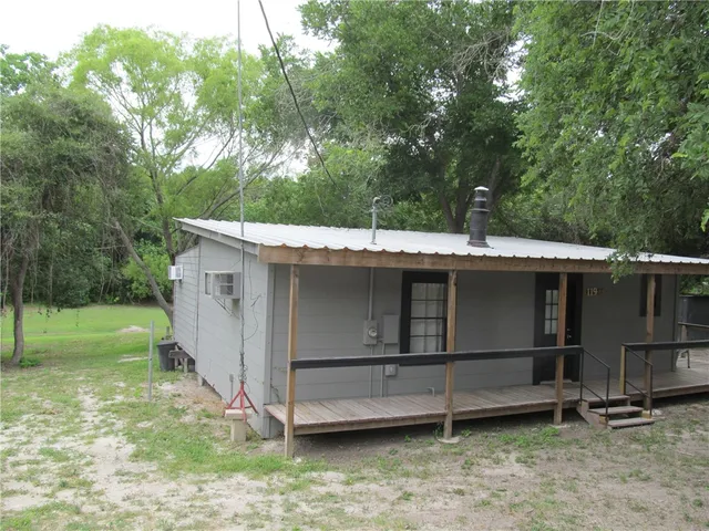 a view of backyard with wooden fence and large trees