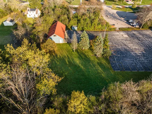 a aerial view of a house with a yard and large trees
