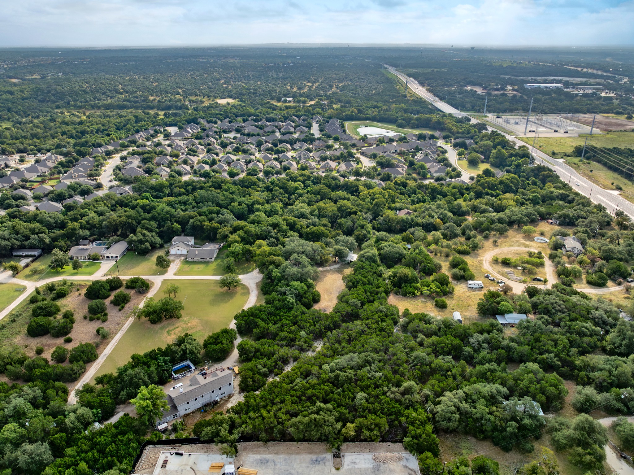 5021 Little Valley Road Leander, TX 78641 - Photo 28 of 32 Aerial context view of mature woodland, open areas, and nearby commercial development.