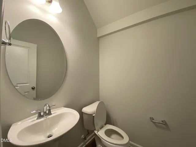 a bathroom with a sink mirror and toilet