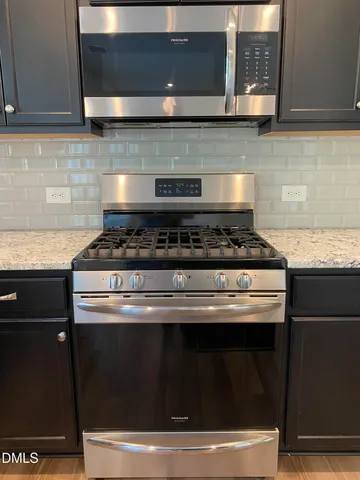 a stove top oven sitting inside of a kitchen