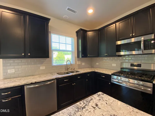 a kitchen with a sink and a stove top oven
