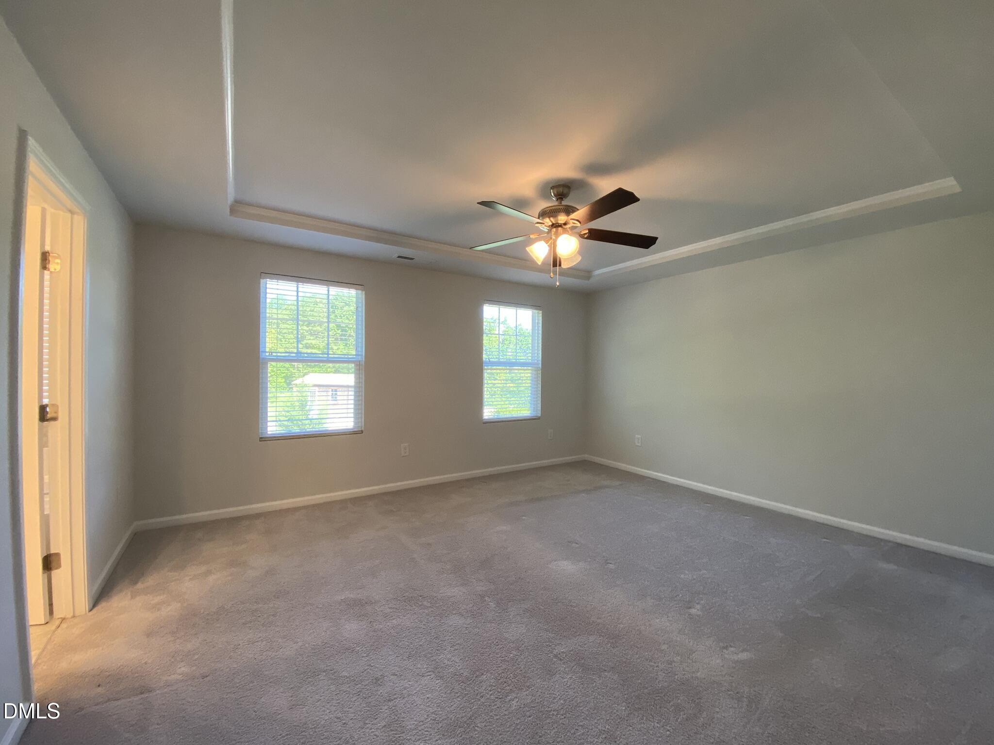 218 Loxton Street Fuquay-Varina, NC 27526 - Photo 27 of 37 an empty room with chandelier fan and windows