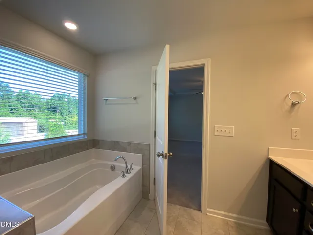 a spacious bathroom with a bathtub and a sink