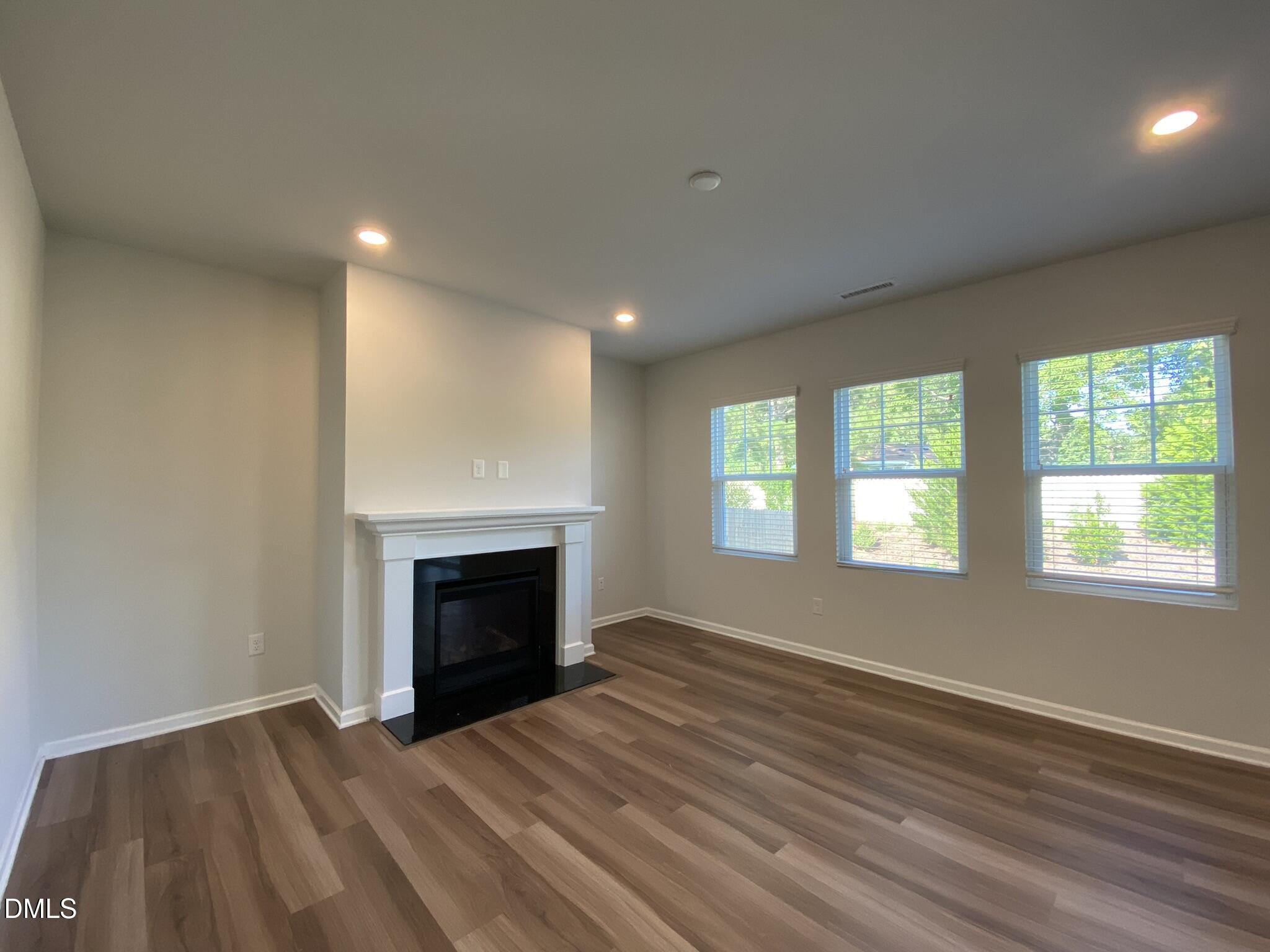 218 Loxton Street Fuquay-Varina, NC 27526 - Photo 9 of 37 an empty room with windows and fireplace