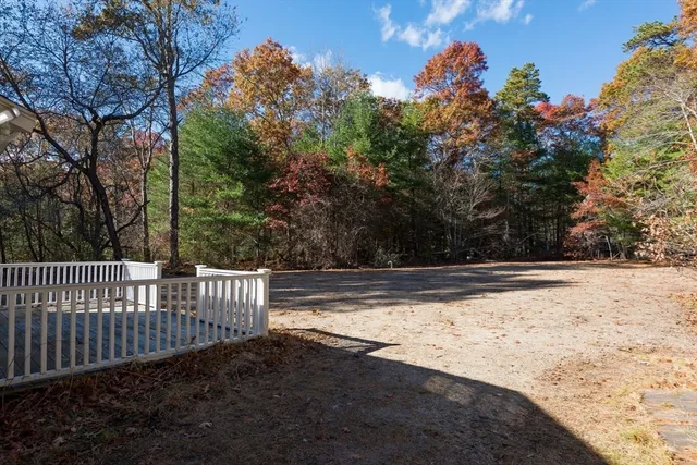 a view of a yard with wooden fence