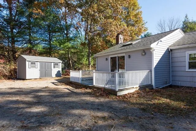 a view of a house with a yard and large tree