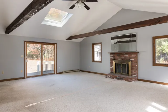 an empty room with windows and fireplace