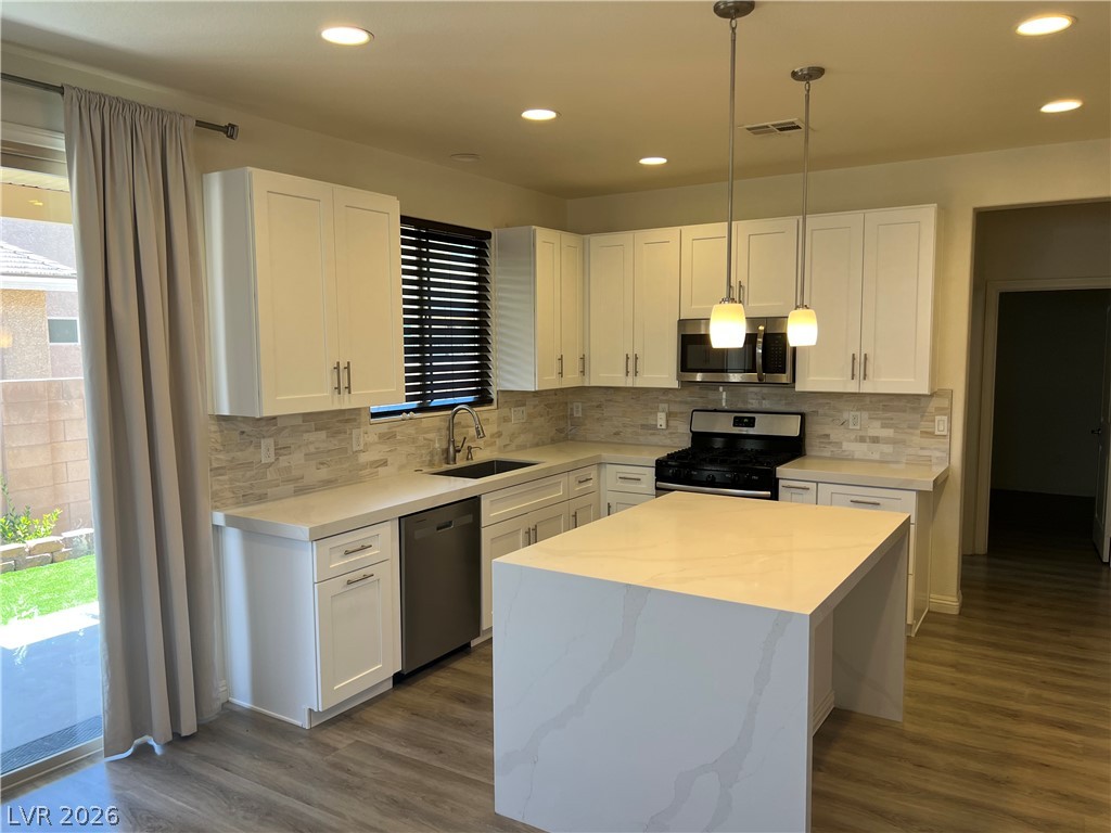 9581 Aberdeen Ridge Court Las Vegas, NV 89148 - Photo 6 of 25 A well-lit, open-concept kitchen with contemporary white cabinetry and a functional central island.