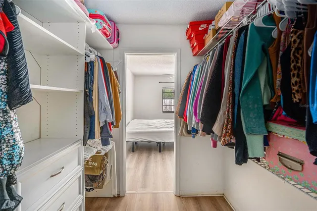 a view of walk in closet with clothes and shoes