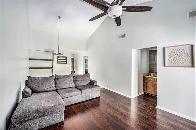 a living room with furniture and a wooden floor