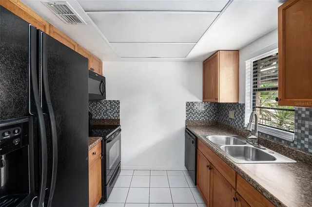 a kitchen with granite countertop a sink and a refrigerator