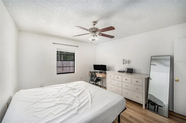 a bedroom with a bed dresser and a flat tv screen