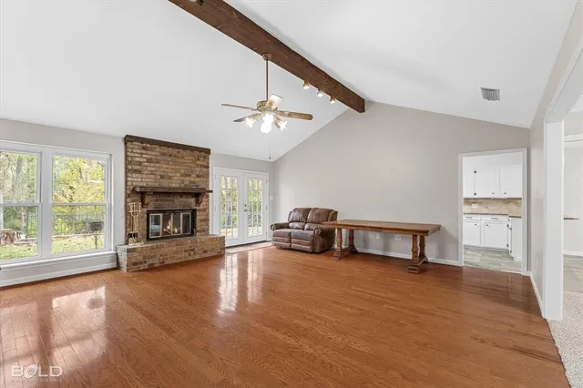 a view of an empty room with window and fireplace