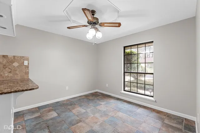 a kitchen with granite countertop a sink a stove and refrigerator