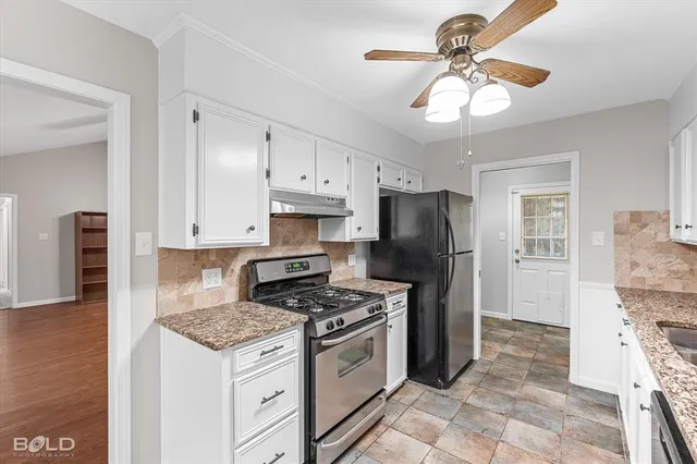 a kitchen with granite countertop a sink stainless steel appliances and cabinets