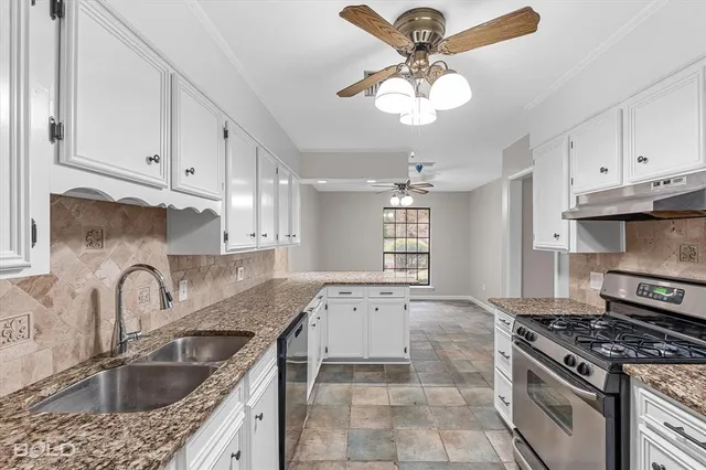 a kitchen with stainless steel appliances granite countertop a stove cabinets and entryway