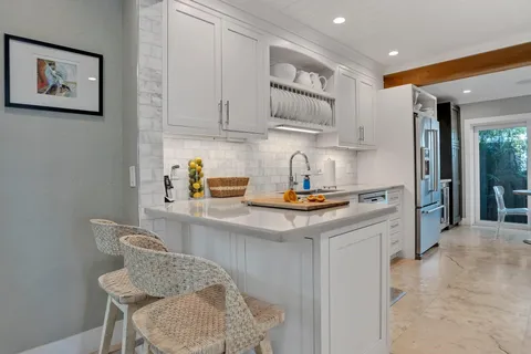 a kitchen with stainless steel appliances granite countertop a sink and a white cabinets