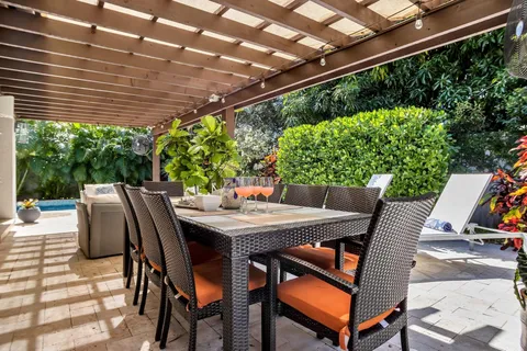 a view of patio with table and chairs and potted plants