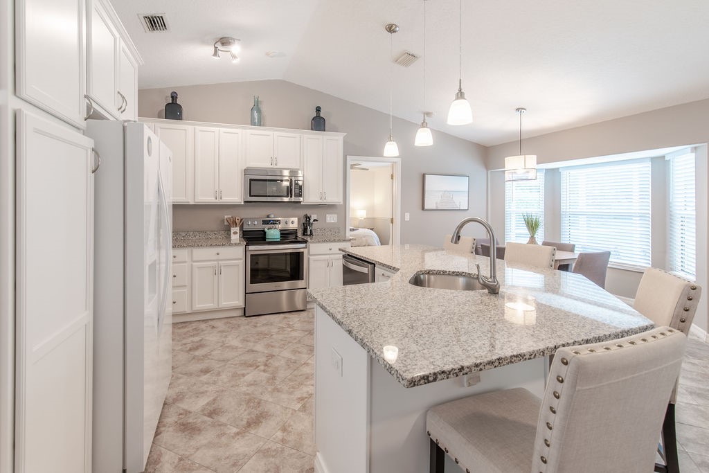 3673 2nd Place Southwest Vero Beach, FL 32968 - Photo 12 of 33 a large kitchen with granite countertop lots of counter top space and refrigerator