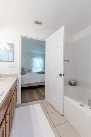 a bathroom with a tub shower and sink