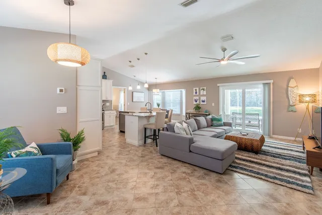 a living room with furniture potted plant and a chandelier