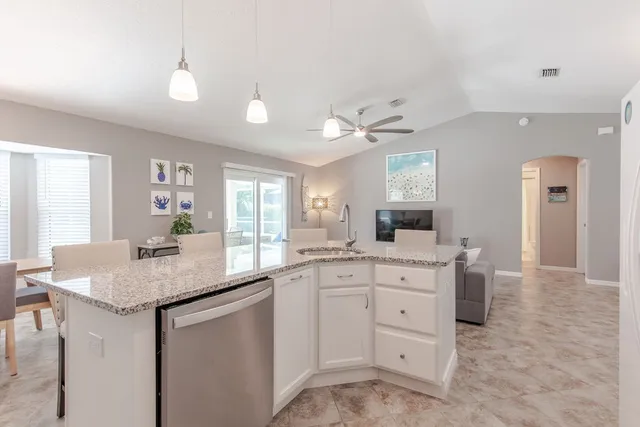 a kitchen with white cabinets and sink