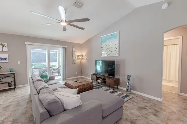 a living room with furniture window and a ceiling fan