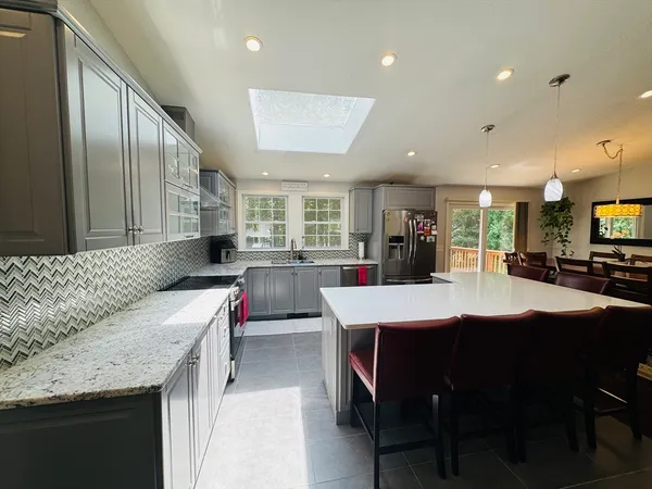 a kitchen with stainless steel appliances kitchen island granite countertop a sink and cabinets