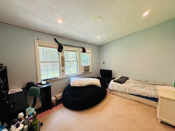 a bedroom with a bed mirror and window