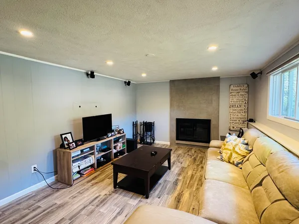 a living room with furniture a fireplace and a flat screen tv