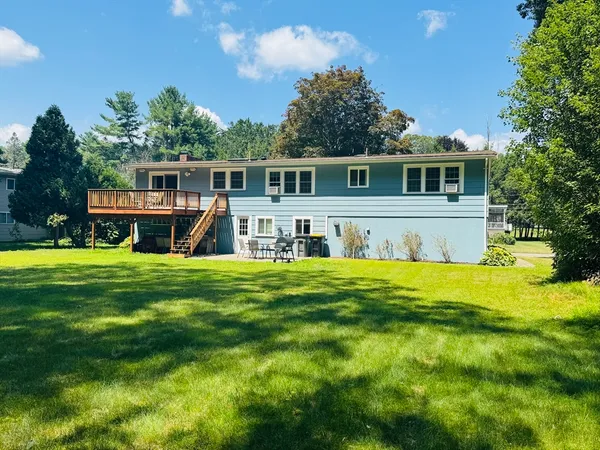 a view of a house with a swimming pool and a yard