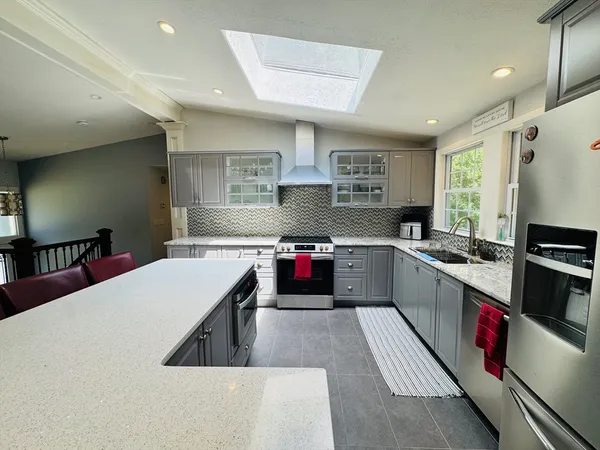 a kitchen with stainless steel appliances granite countertop a stove sink and cabinets