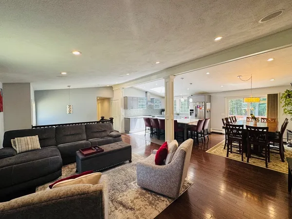 a living room with furniture kitchen view and a large window