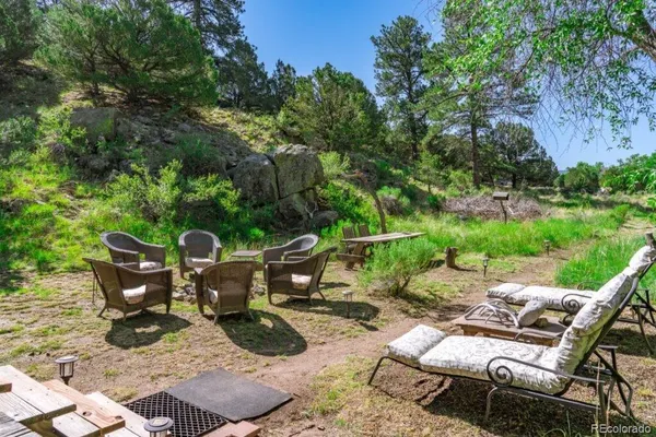a view of a patio with table and chairs potted plants and large tree