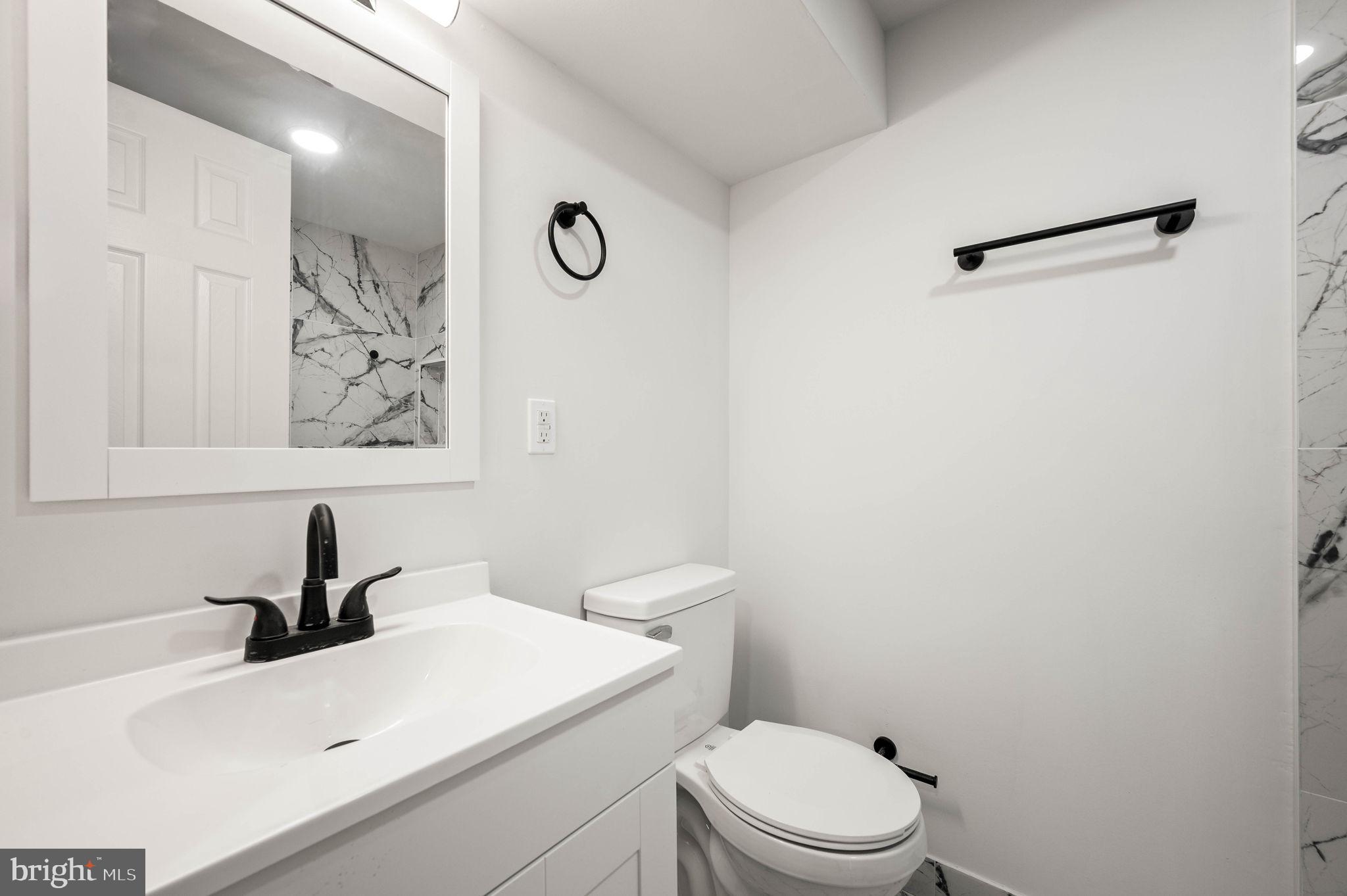 1852 East Lippincott Street Philadelphia, PA 19134 - Photo 11 of 25 a bathroom with a sink a toilet and a mirror
