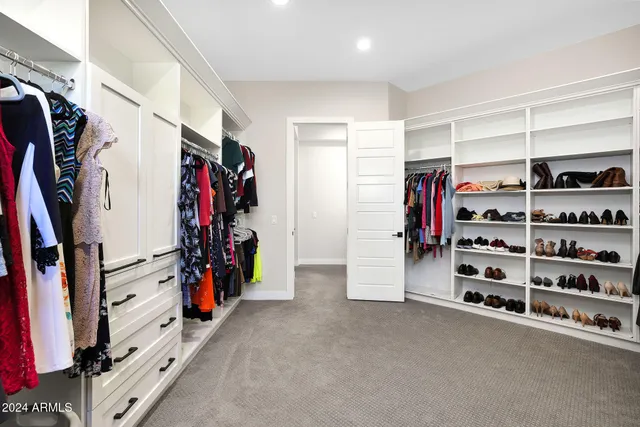 a view of walk in closet with clothes and shoes