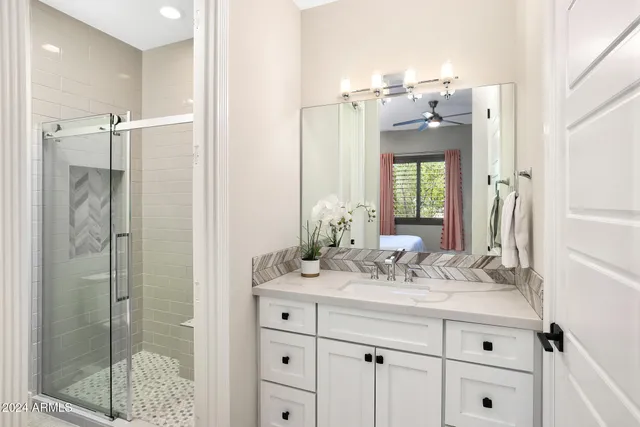 a bathroom with a double vanity sink mirror and shower
